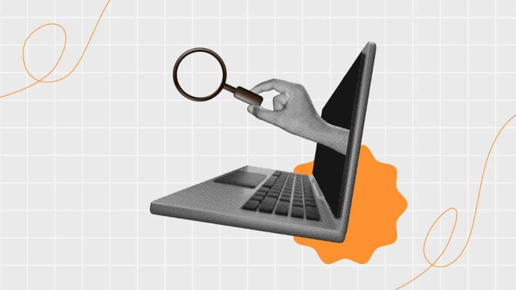 Mano con lente d'ingrandimento esce dallo schermo di un portatile, simbolo del digital marketing.